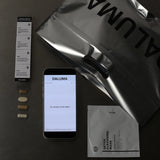 Auf einer flachen Unterlage befinden sich vier Ergänzungskapseln, eine Beipackzettel, ein Smartphone mit DALUMA, eine DALUMA Metalltasche und eine DETOX CLEANSING MASK - alles, was Sie für Ihre BESSERE SAFTKUR PLUS - 3 TAGE by DALUMA benötigen.