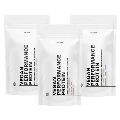Drei weiße, wiederverschließbare Beutel mit DALUMA VEGANES PERFORMANCE PROTEIN ALL FLAVORS sind in einer Reihe angeordnet. Die minimalistische Verpackung zeigt fetten schwarzen Text. Dieses pflanzliche Protein hat den Geschmack von Creamy Vanilla und einen Aminosäurekomplex.