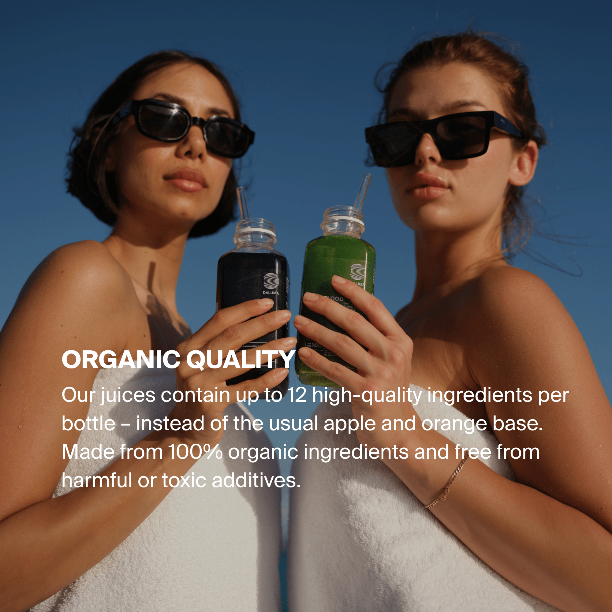 Zwei Frauen mit Sonnenbrillen und Handtüchern halten Flaschen mit DALUMA INSIDE-OUT SUMMERBODY CLEANSE - 3 TAGE Säften vor einem blauen Himmel. Der überlagerte Text hebt die Bio-Säfte hervor, die aus hochwertigen, ungiftigen Zutaten hergestellt werden.